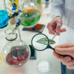 Chemicals, beakers and magnifying glass